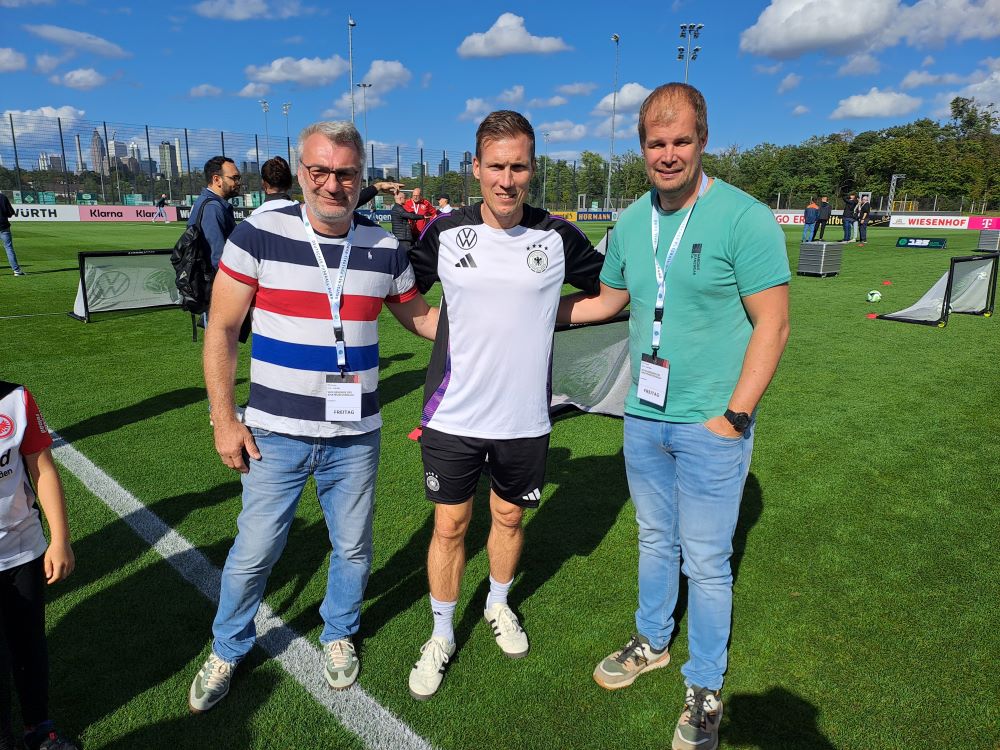 Herr Bürgel und Herr Kath mit Fußballtrainer Hannes Wolf