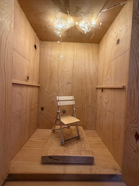 Hölzerner, beleuchteter Raum mit kleinem Stuhl, Skulptur entstanden im Rahmen der Kunstwoche der 8.2