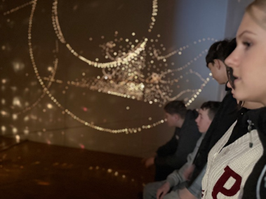 Die Schüler*innen betrachten die Installationen zu "Licht und Schatten"