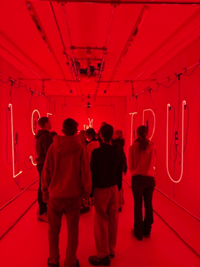 Die Schüler*innen in einem rot beleuchteten Raum